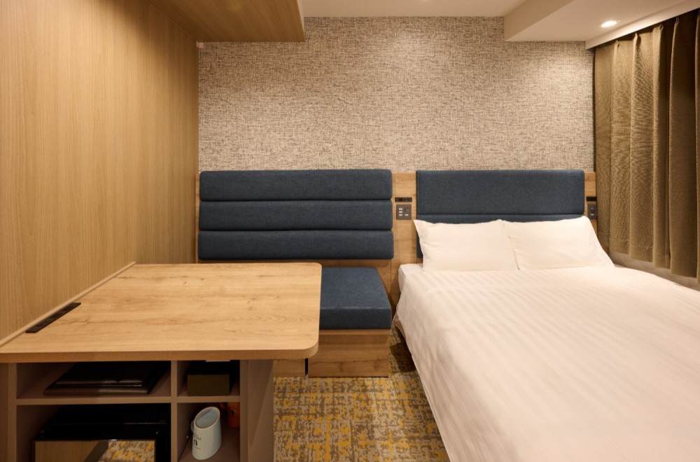 A bed and a spacious deskin the Viainn Double Room at  Via Inn Shinagawa-Oimachi