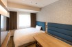 A bed and a spacious deskin the Viainn Single Room at  Via Inn Shinagawa-Oimachi