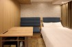 A bed and a spacious deskin the Viainn Double Room at  Via Inn Shinagawa-Oimachi