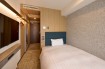 The bed and smart TV in the Standard Single A room at Via Inn Shinagawa-Oimachi